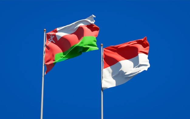 Beautiful national state flags of Oman and Indonesia together on blue sky