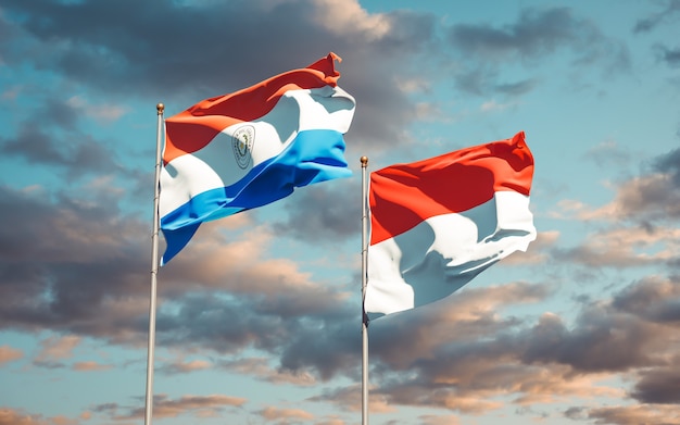 Beautiful national state flags of Paraguay and Indonesia together on blue sky