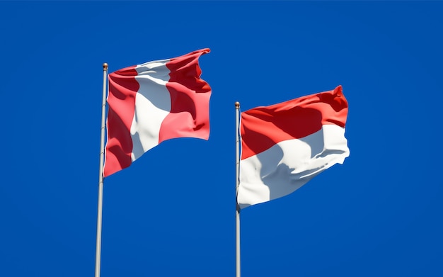 Photo beautiful national state flags of peru and indonesia together on blue sky