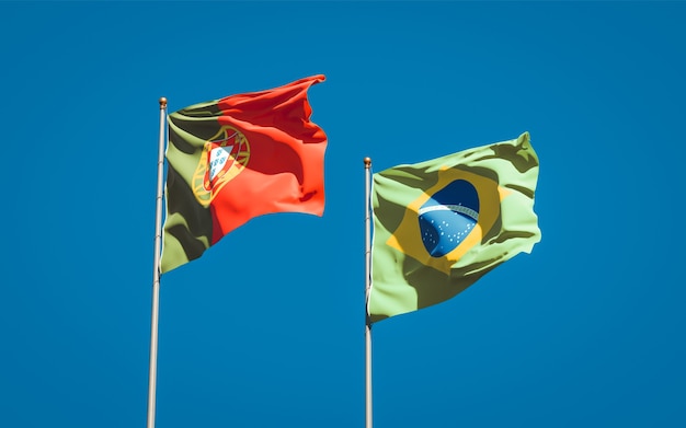 Beautiful national state flags of Portugal and Brasil together on blue sky