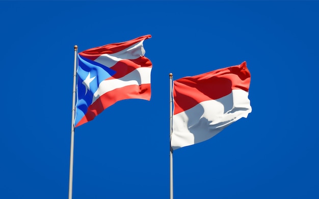 Beautiful national state flags of Puerto Rico and Indonesia together on blue sky