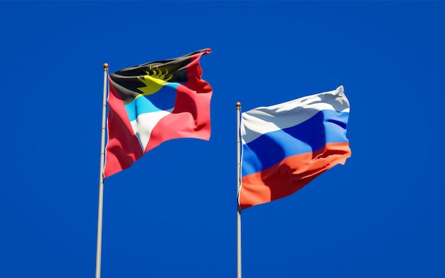 Beautiful national state flags of Russia and Antigua and Barbuda together on blue sky. 3D artwork