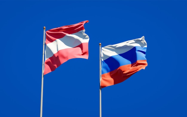 Beautiful national state flags of Russia and Austria together on blue sky. 3D artwork