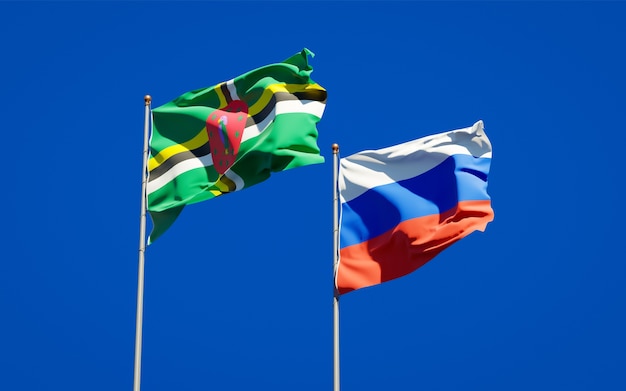 Beautiful national state flags of Russia and Dominica together on blue sky. 3D artwork