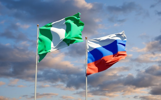 Beautiful national state flags of russia and russia together on
blue sky. 3d artwork