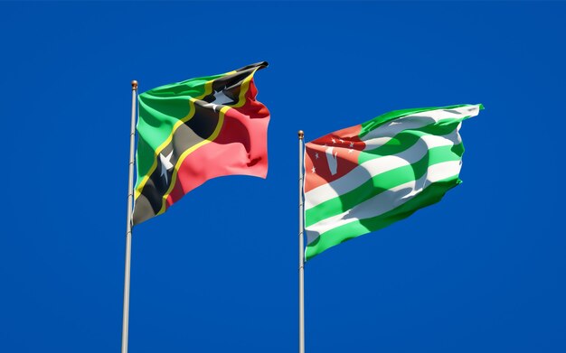 Beautiful national state flags of Saint Kitts and Nevis and Abkhazia together on blue sky. 3D artwork