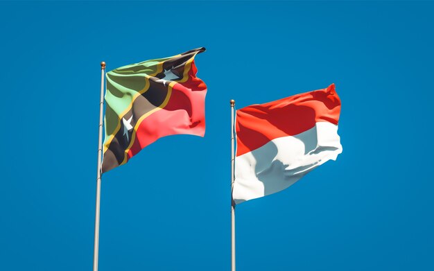 Beautiful national state flags of Saint Kitts and Nevis and Indonesia together on blue sky