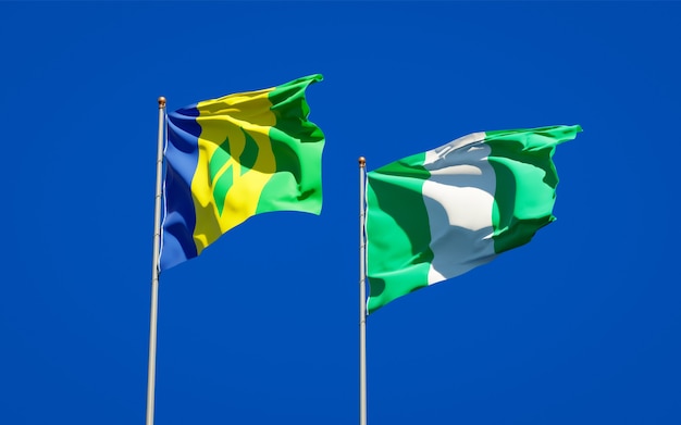 Beautiful national state flags of Saint Vincent and the Grenadines and Nigeria together on blue sky