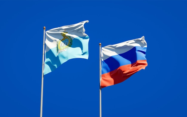 Beautiful national state flags of San Marino and Russia together on blue sky. 3D artwork