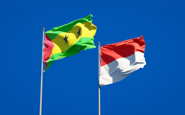 Foto belle bandiere nazionali dello stato di sao tome e principe e indonesia insieme sul cielo blu