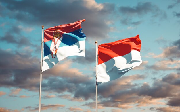 Beautiful national state flags of Serbia and Indonesia together on blue sky