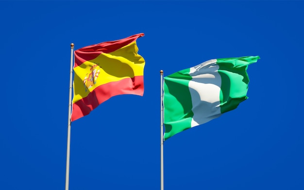 Beautiful national state flags of Spain and Nigeria together on blue sky