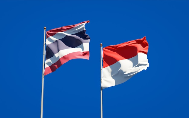 Beautiful national state flags of Thailand and Indonesia together on blue sky