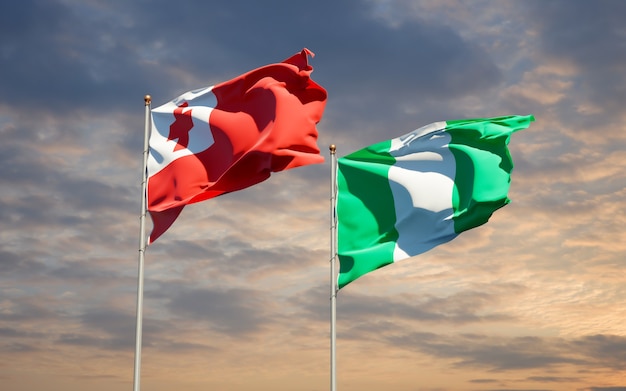 Beautiful national state flags of Tonga and Nigeria together on blue sky