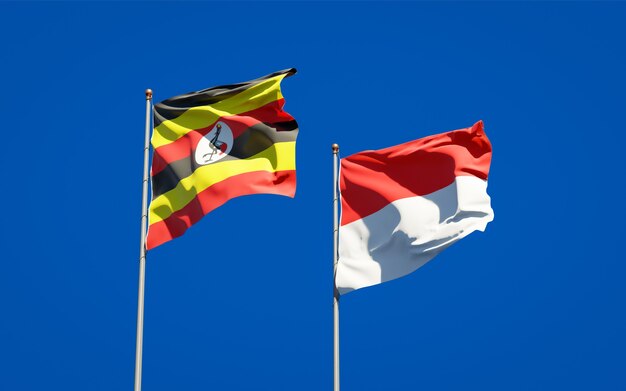 Belle bandiere di stato nazionali dell'uganda e dell'indonesia insieme sul cielo blu