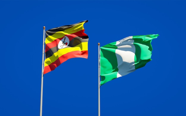 Beautiful national state flags of Uganda and Nigeria together on blue sky