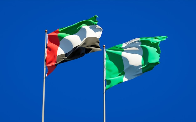 Beautiful national state flags of United Arab Emirates UAE and Nigeria together on blue sky