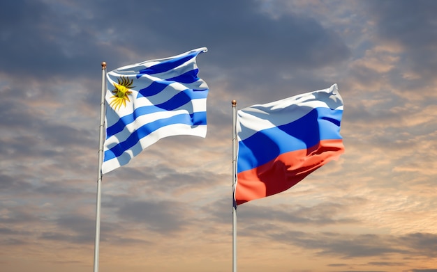 Beautiful national state flags of Uruguay and Russia together on blue sky. 3D artwork