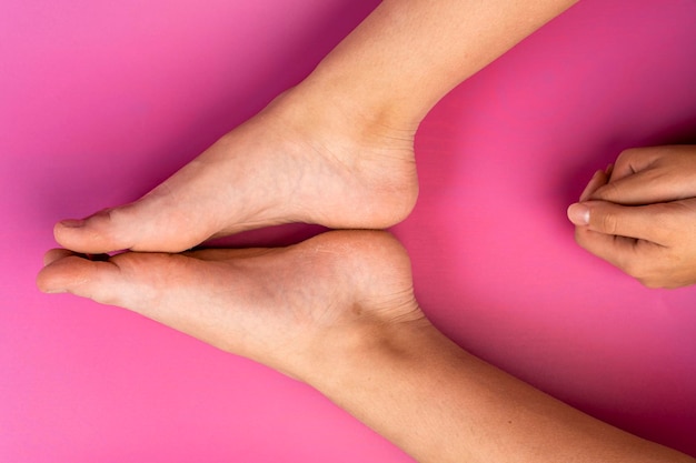 Beautiful natural legs and arms of a teenage girl on a pink background