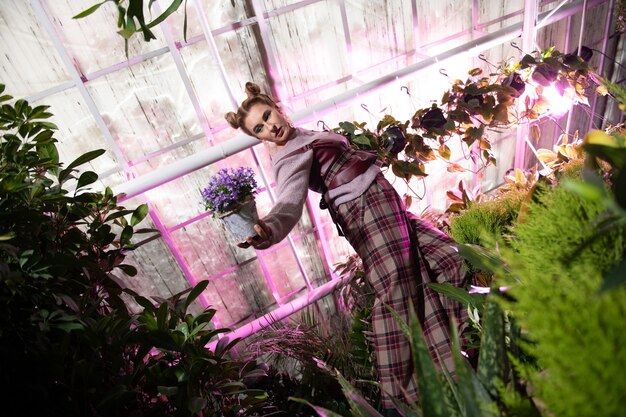 Beautiful nature. Attractive young woman being in the flower garden while having a photo shoot there