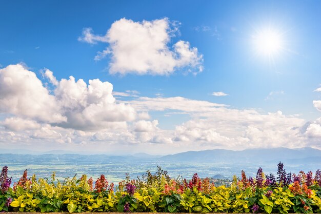 Photo beautiful nature landscape of bright sun and white clouds on blue sky background above the flower balcony on the mountain in thailand