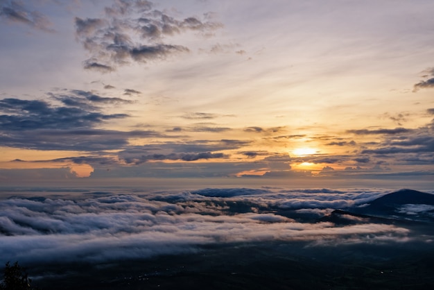 Beautiful nature landscape the sun is above the sea fog that\
covers the mountains and bright sky during sunrise in the winter at\
viewpoint of phu ruea national park, loei province, thailand.