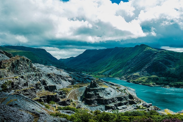 Beautiful nature landscape with a grassy and mined mountain combination under a cloudy sky