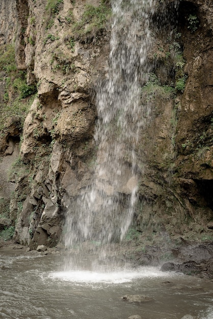 Beautiful nature. Mountain waterfall surrounded with trees and fog