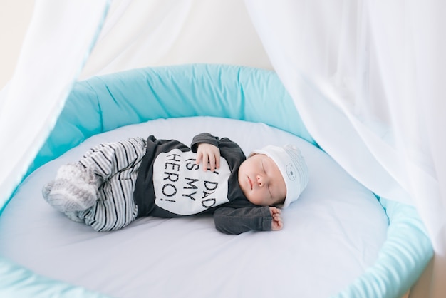 Beautiful newborn baby lying in an oval bed