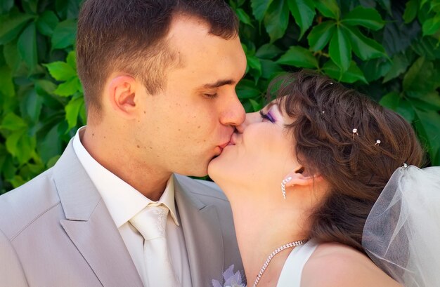 Photo beautiful newly married couple are kissing in the park