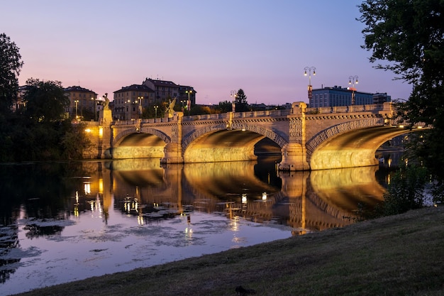 Foto bella vista notturna del ponte sul fiume po nella città di torino italia