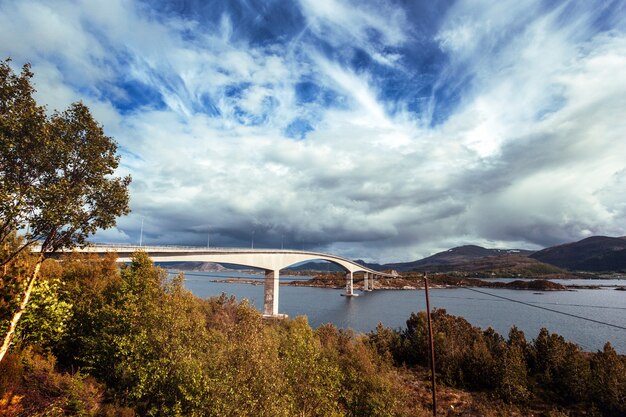Красивый норвежский пейзаж. мост против красивого голубого неба с облаками