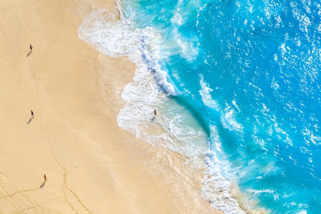 Beautiful ocean waves and white beach with people from top