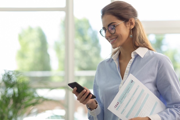 Beautiful office worker looking at her gadget