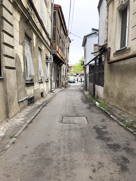 Beautiful old brown dilapidated threestory houses of the building in a pebble on a narrow street