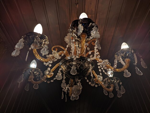 beautiful old chandelier hanging on a wooden brown ceiling