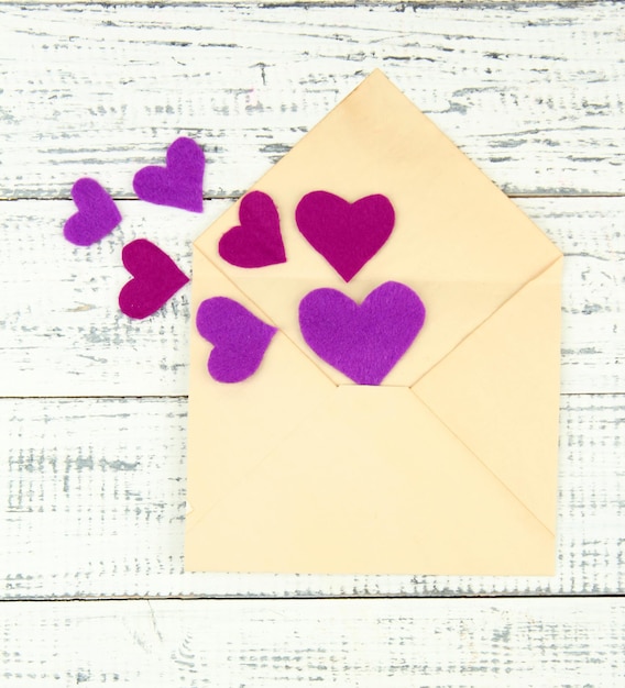 Beautiful old envelope with decorative hearts on wooden background