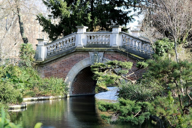 Beautiful old stone bridge with railing over clean river in preserve natural nature consisting of arched stone ancient bridge over long river over deep blue river standing decrepit stone bridge