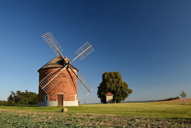 Foto bellissimo vecchio mulino a vento e paesaggio con il tramonto chvalkovice repubblica ceca europa