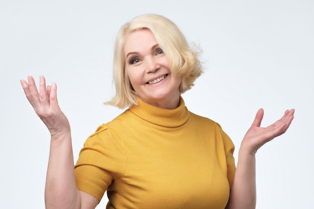 Beautiful older woman in yellow sweater smiling