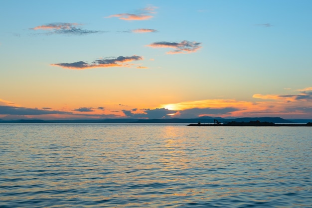 自然の概念の美しさのソフトセレクティブフォーカスで海に沈む美しいオレンジ色の夕日