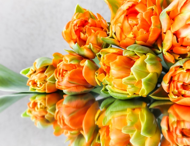 Beautiful orange tulips on the mirror perfect for background greeting card