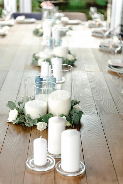 Bella decorazione di nozze all'aperto in città candele accessori mazzi di fiori e bicchieri su tavola piatta
