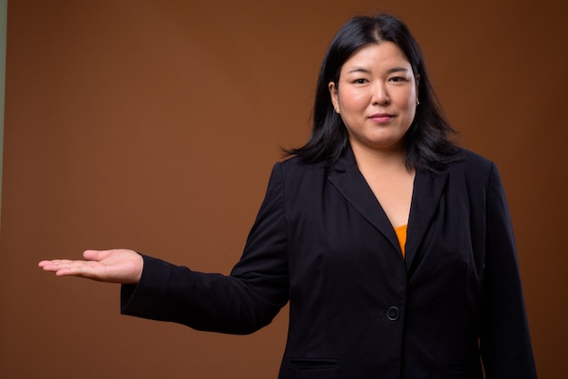 beautiful overweight Asian businesswoman on brown