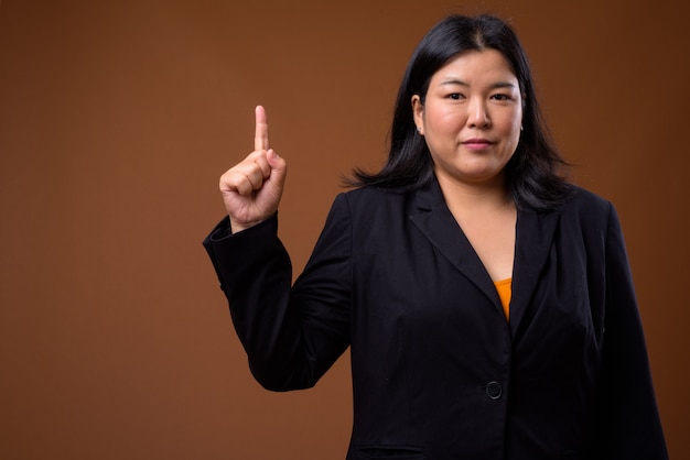 beautiful overweight Asian businesswoman on brown