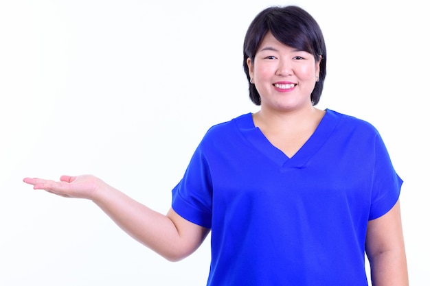 beautiful overweight Asian businesswoman with short hair isolated against white wall