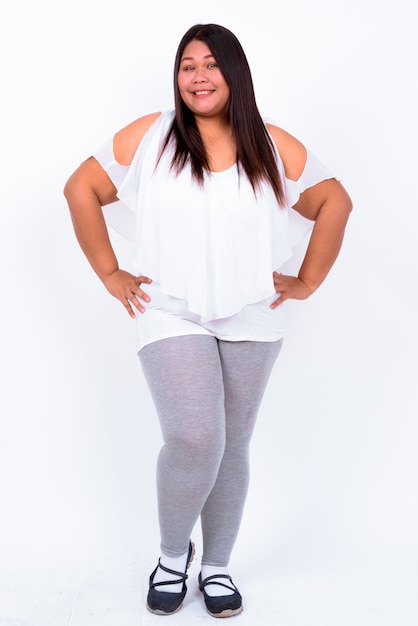 Beautiful overweight Asian woman against white wall