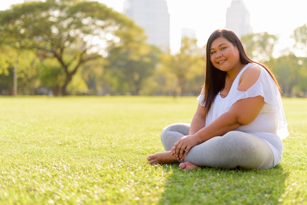 Beautiful overweight Asian woman relaxing at the park