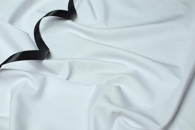 Красивые окисленные украшения на белой шелковой ткани и красно-черной ленте