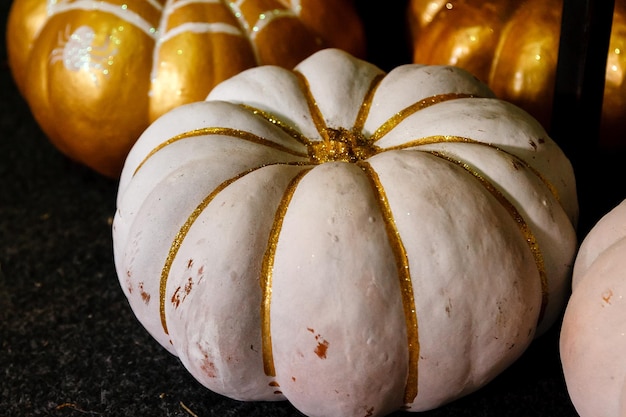 Beautiful painted pumpkins of white and gold color on halloween